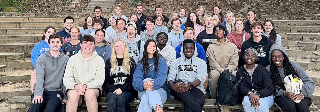 A large group of smiling students sitting on a tiered series of benches